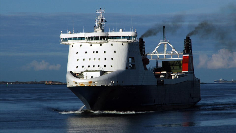 Färja på hav med avgaser från skorstenar