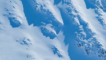 Offpist-skidåkare åker nedför orört snöfält