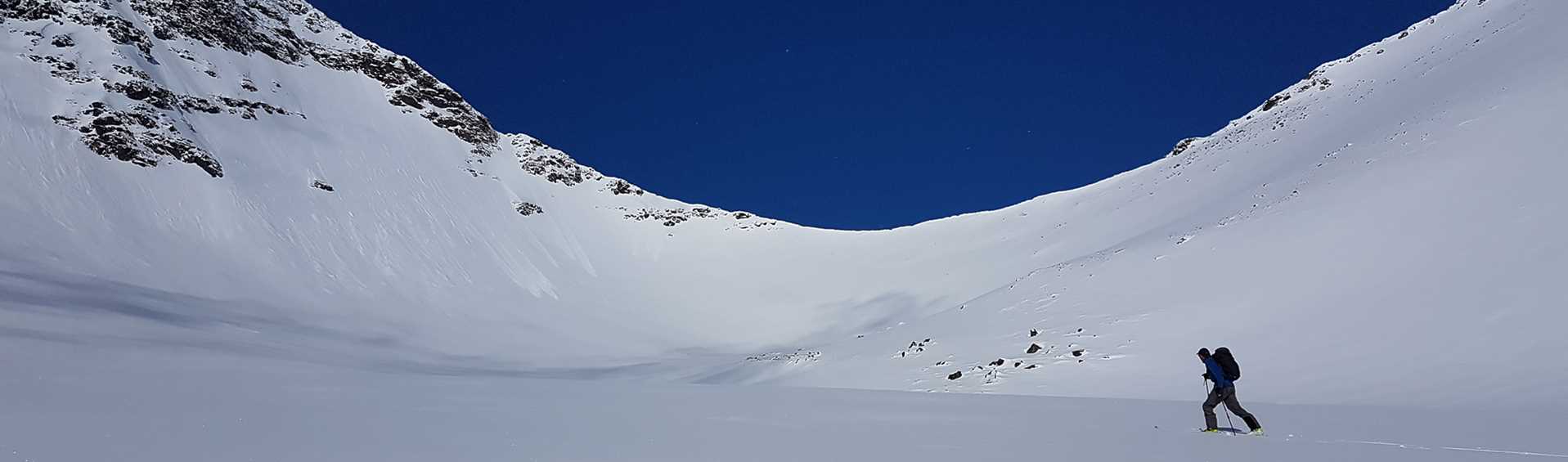 Single skier going over a snow plain